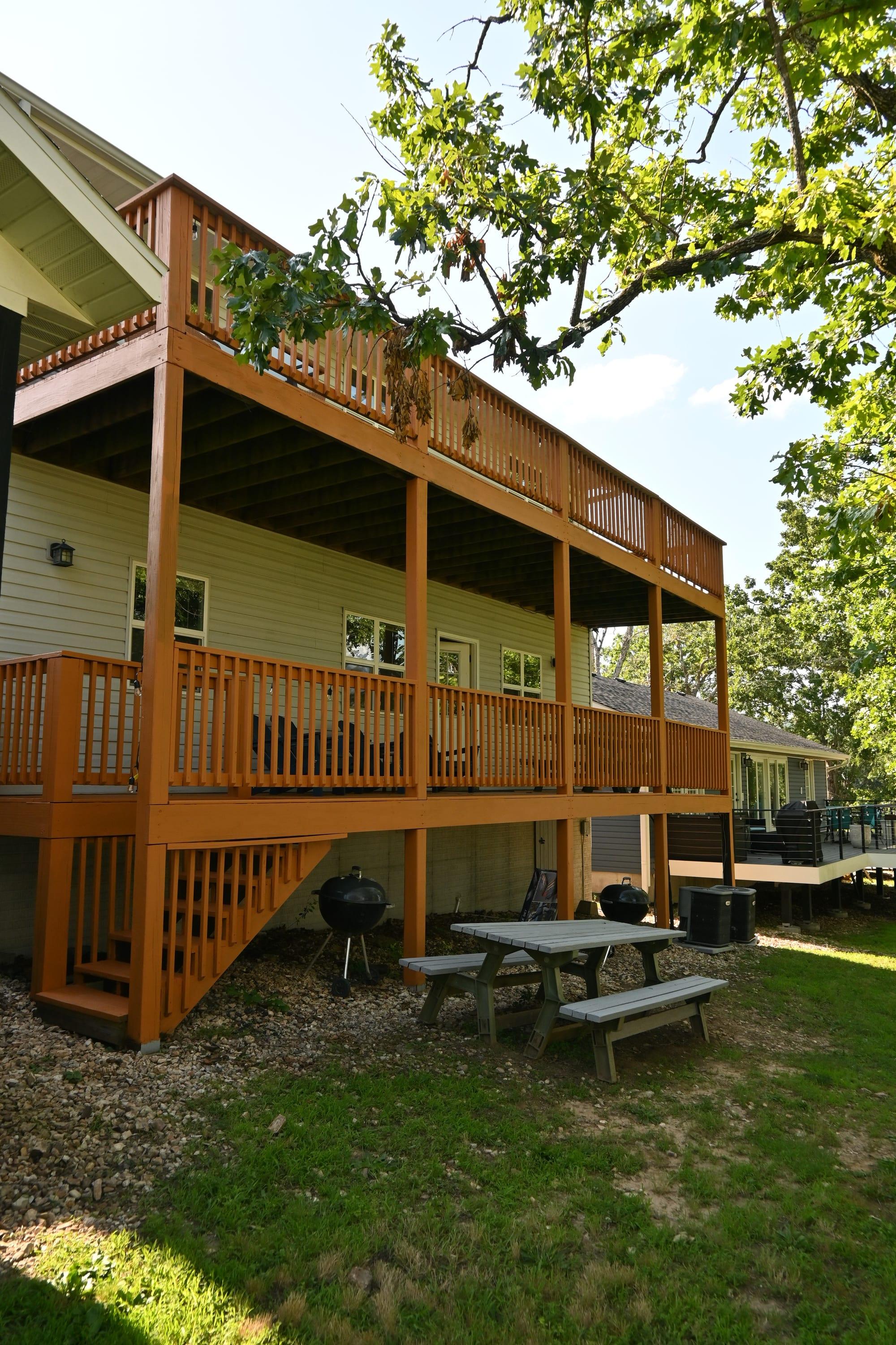Two-level covered decks with grills and a picnic table at Dock Holiday Suites