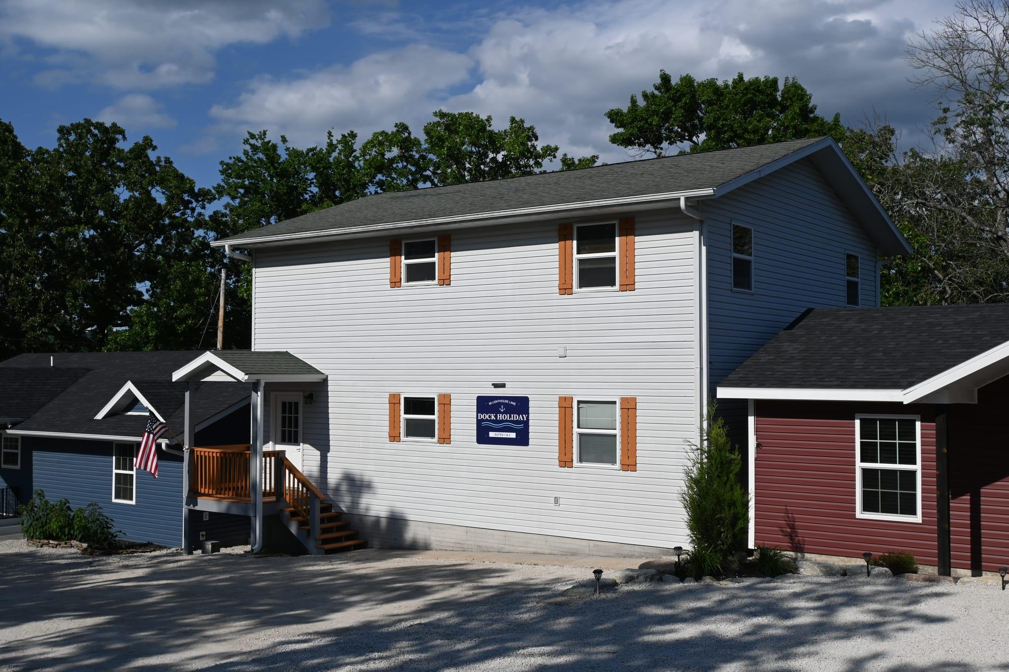 Front exterior of the Dock Holiday Suites building with its sign at Port of Kimberling Marina